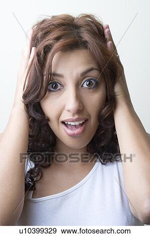 Stock Photo - Portrait of a young woman looking surprised. Fotosearch