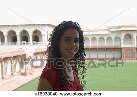 Stock Photo - Portrait of a young woman smiling, Taj Mahal, Agra, Uttar Pradesh, India. Fotosearch