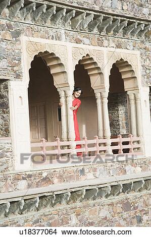 Portrait of a young woman standing in the balcony of a palace, Neemrana Fort Palace, Neemrana, Alwar, Rajasthan, India View Large Photo Image Picture - Portrait of a young woman standing in the balcony of a palace, Neemrana Fort Palace, Neemrana, Alwar, Rajasthan, India. Fotosearch