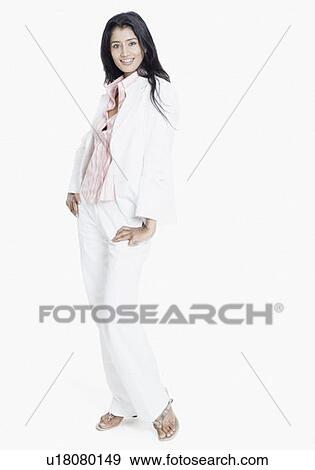 Stock Photo - Portrait of a young woman standing with her arms akimbo and smiling. Fotosearch
