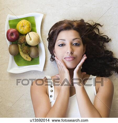 Portrait of a young woman touching her face View Large Photo Image Picture - Portrait of a young woman touching her face. Fotosearch