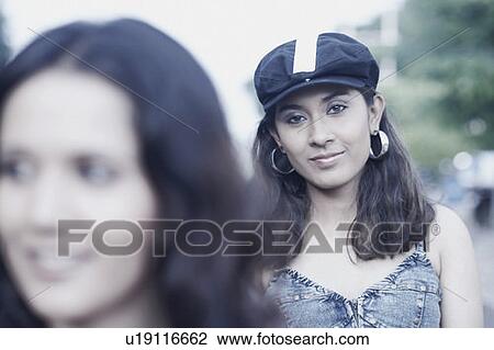 Stock Image - Portrait of a young woman wearing a cap. Fotosearch