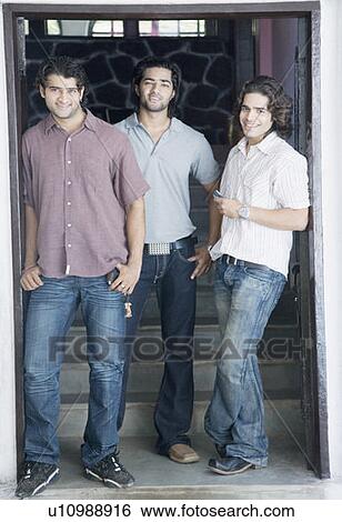 Stock Photograph - Portrait of three young men standing together and smiling. Fotosearch
