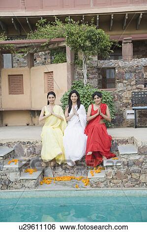 Portrait of three young women sitting at the poolside and smiling View Large Photo Image Stock Photograph - Portrait of three young women sitting at the poolside and smiling. Fotosearch