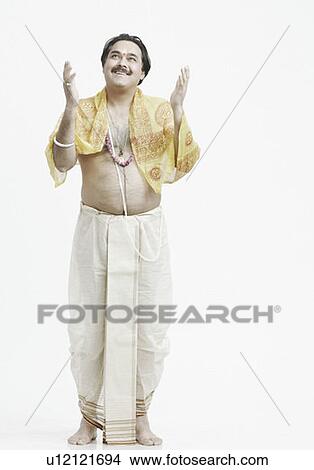 Picture - Priest standing with his arms raised. Fotosearch