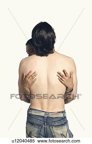 Stock Photography - Rear view of a man embracing a young woman. Fotosearch