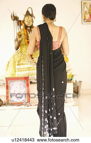 Rear view of a young woman praying in front of an idol of Lord Shiva View Large Photo Image Stock Image - Rear view of a young woman praying in front of an idol of Lord Shiva. Fotosearch