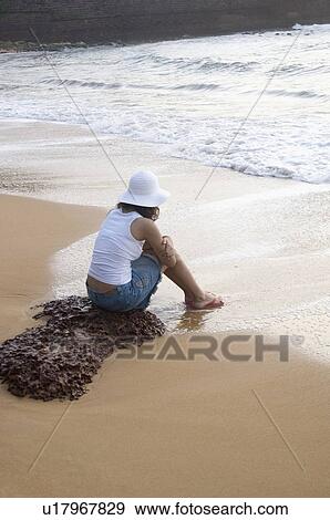 Rear view of a young woman sitting on the beach, Goa, India View Large Photo Image Stock Photo - Rear view of a young woman sitting on the beach, Goa, India. Fotosearch