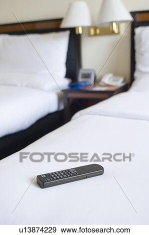 Remote control on the bed in a hotel room View Large Photo Image Stock Photo - Remote control on the bed in a hotel room. Fotosearch