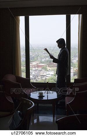 Side profile of a businessman reading a newspaper in a lobby View Large Photo Image Stock Photography - Side profile of a businessman reading a newspaper in a lobby. Fotosearch