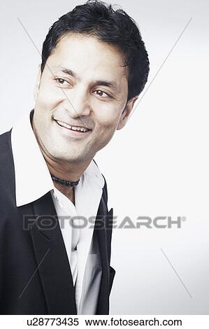 Stock Photography - Side profile of a businessman smiling. Fotosearch