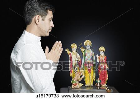 Side profile of a mid adult man praying in front of a Hindu idol View Large Photo Image Stock Image - Side profile of a mid adult man praying in front of a Hindu idol. Fotosearch