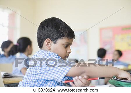 Picture - Side profile of a schoolboy in a classroom. Fotosearch