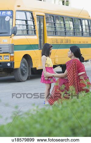 Stock Photo - Side profile of a teacher talking to a schoolgirl. Fotosearch