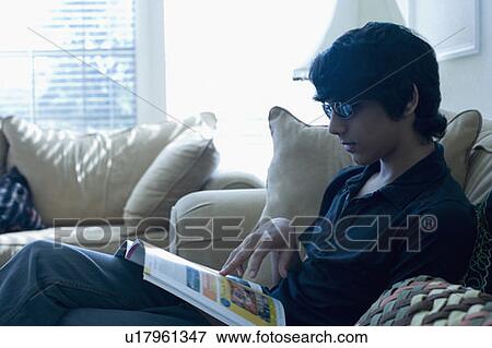 Side profile of a teenage boy reading a magazine View Large Photo Image Stock Photo - Side profile of a teenage boy reading a magazine. Fotosearch