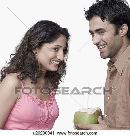 Side profile of a young couple holding coconut milk and smiling View Large Photo Image Stock Image - Side profile of a young couple holding coconut milk and smiling. Fotosearch