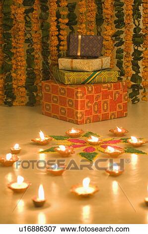 Stock Photo - Stack of gifts near oil lamps. Fotosearch