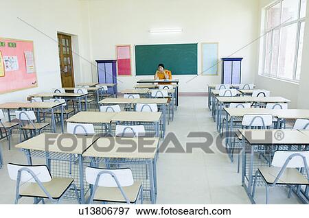 Teacher sitting in an empty classroom View Large Photo Image Stock Photo - Teacher sitting in an empty classroom. Fotosearch