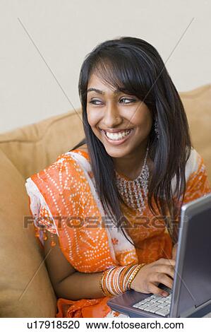 Stock Image - Teenage girl working on a laptop. Fotosearch