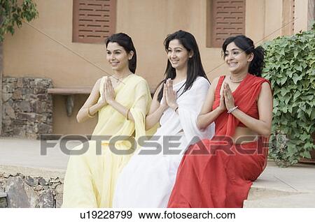 Stock Photo - Three young women greeting and smiling, India. Fotosearch