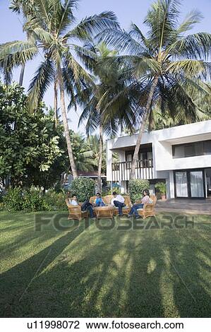 Two couples sitting in a lawn View Large Photo Image Stock Image - Two couples sitting in a lawn. Fotosearch