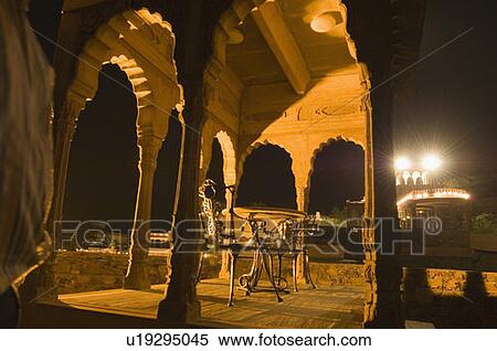 Stock Photography - Two iron chairs in a fort at night, Neemrana Fort, Alwar, Rajasthan, India. Fotosearch