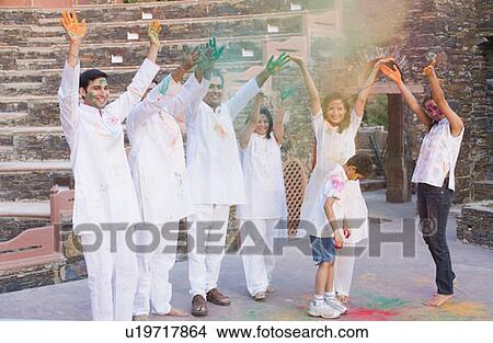 Picture - Two mid adult couples and a young couple with a boy celebrating holi. Fotosearch