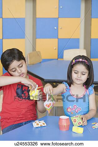 Two students making paper craft products in a classroom View Large Photo Image Stock Photograph - Two students making paper craft products in a classroom. Fotosearch