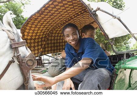 Two young men traveling in a horse cart View Large Photo Image Stock Photography - Two young men traveling in a horse cart. Fotosearch