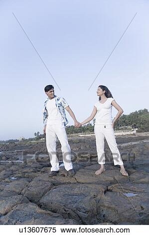 Young couple standing on rocks with holding their hands View Large Photo Image Stock Photography - Young couple standing on rocks with holding their hands. Fotosearch