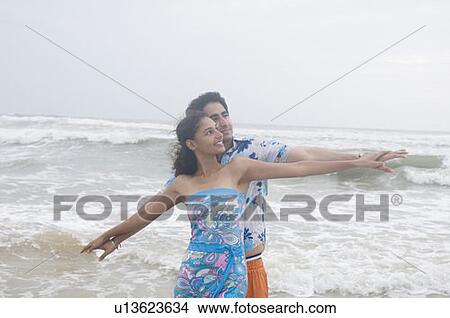 Young couple standing on the beach View Large Photo Image Picture - Young couple standing on the beach. Fotosearch