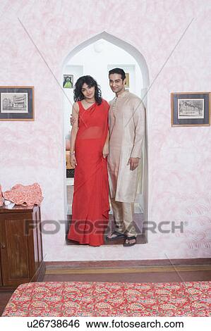 Stock Photograph - Young couple standing together under an arch. Fotosearch