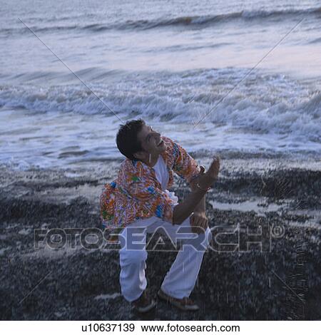 Stock Photo - Young man having fun on the beach. Fotosearch