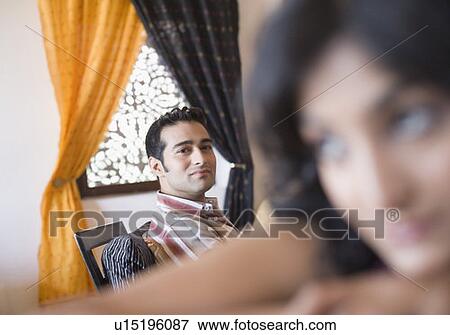Stock Photo - Young man looking at a young woman in front of him. Fotosearch