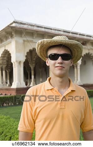 Young man standing in front of a mausoleum, Taj Mahal, Agra, Uttar Pradesh, India View Large Photo Image Picture - Young man standing in front of a mausoleum, Taj Mahal, Agra, Uttar Pradesh, India. Fotosearch