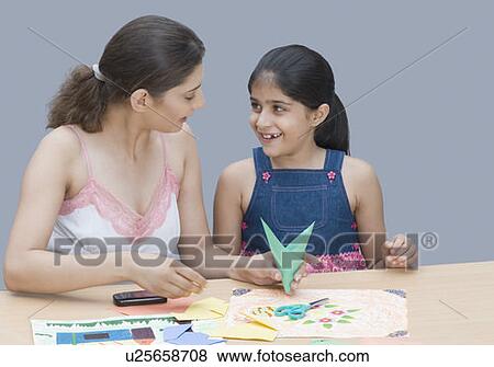 Stock Photo - Young woman helping her daughter in drawing. Fotosearch