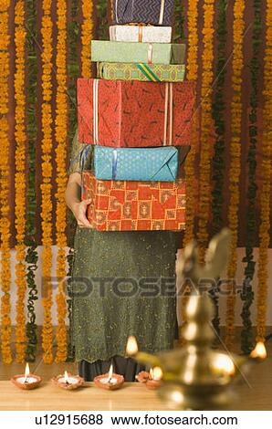 Young woman holding a stack of diwali gifts View Large Photo Image Stock Photo - Young woman holding a stack of diwali gifts. Fotosearch