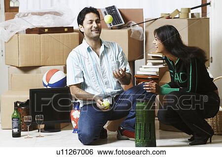Stock Photograph - Young woman laughing at a young man juggling balls. Fotosearch
