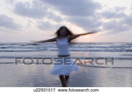 Stock Photo - Young woman running on the beach. Fotosearch