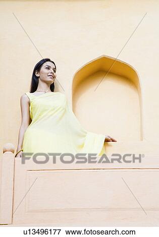 Young woman standing at the balcony and smiling View Large Photo Image Stock Photo - Young woman standing at the balcony and smiling. Fotosearch