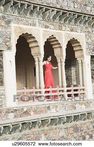 Stock Image - Young woman standing at the balcony of a palace, Neemrana Fort Palace, Neemrana, Alwar, Rajasthan, India. Fotosearch