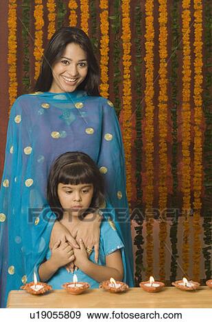 Young woman standing with her daughter in front of oil lamps View Large Photo Image Stock Photo - Young woman standing with her daughter in front of oil lamps. Fotosearch