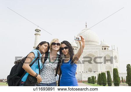 Young woman standing with her friends and taking a picture of themselves, Taj Mahal, Agra, Uttar Pradesh, India View Large Photo Image Stock Image - Young woman standing with her friends and taking a picture of themselves, Taj Mahal, Agra, Uttar Pradesh, India. Fotosearch