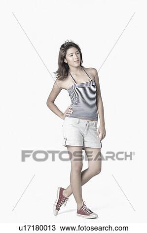 Young woman standing with her hand on her hip View Large Photo Image Stock Image - Young woman standing with her hand on her hip. Fotosearch