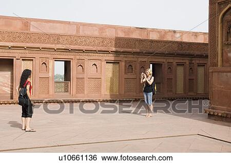 Young woman taking a picture of her friend, Taj Mahal, Agra, Uttar Pradesh, India View Large Photo Image Stock Photograph - Young woman taking a picture of her friend, Taj Mahal, Agra, Uttar Pradesh, India. Fotosearch