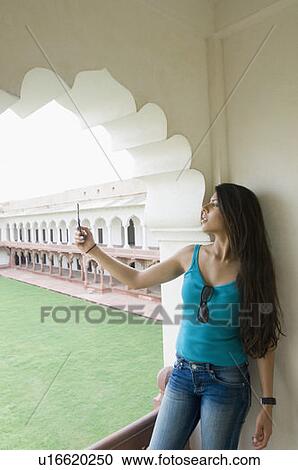 Young woman taking a picture of herself with a mobile phone, Taj Mahal, Agra, Uttar Pradesh, India View Large Photo Image Stock Image - Young woman taking a picture of herself with a mobile phone, Taj Mahal, Agra, Uttar Pradesh, India. Fotosearch