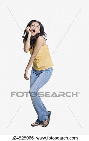 Young woman talking on a mobile phone and posing View Large Photo Image Stock Photograph - Young woman talking on a mobile phone and posing. Fotosearch