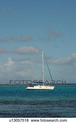 Stock Photo - A sailboat on the sea, Moorea, Tahiti, French Polynesia, South Pacific. Fotosearch