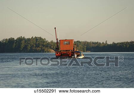 Stock Image - Crane being transported on the lake. Fotosearch
