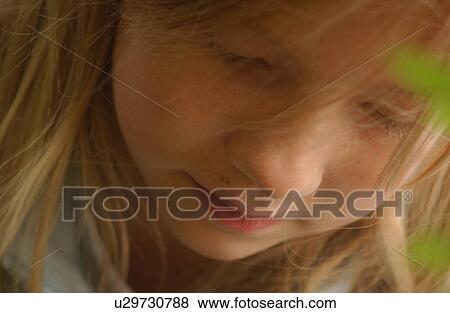 Stock Photo - Close-up of a young girl looking down. Fotosearch